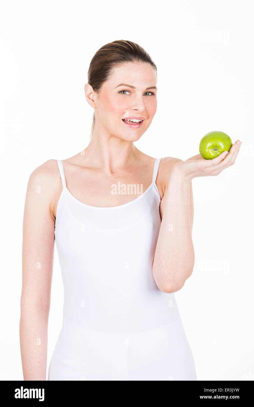 junge Frau hält einen Apfel und Blick in die Kamera Stockfoto
