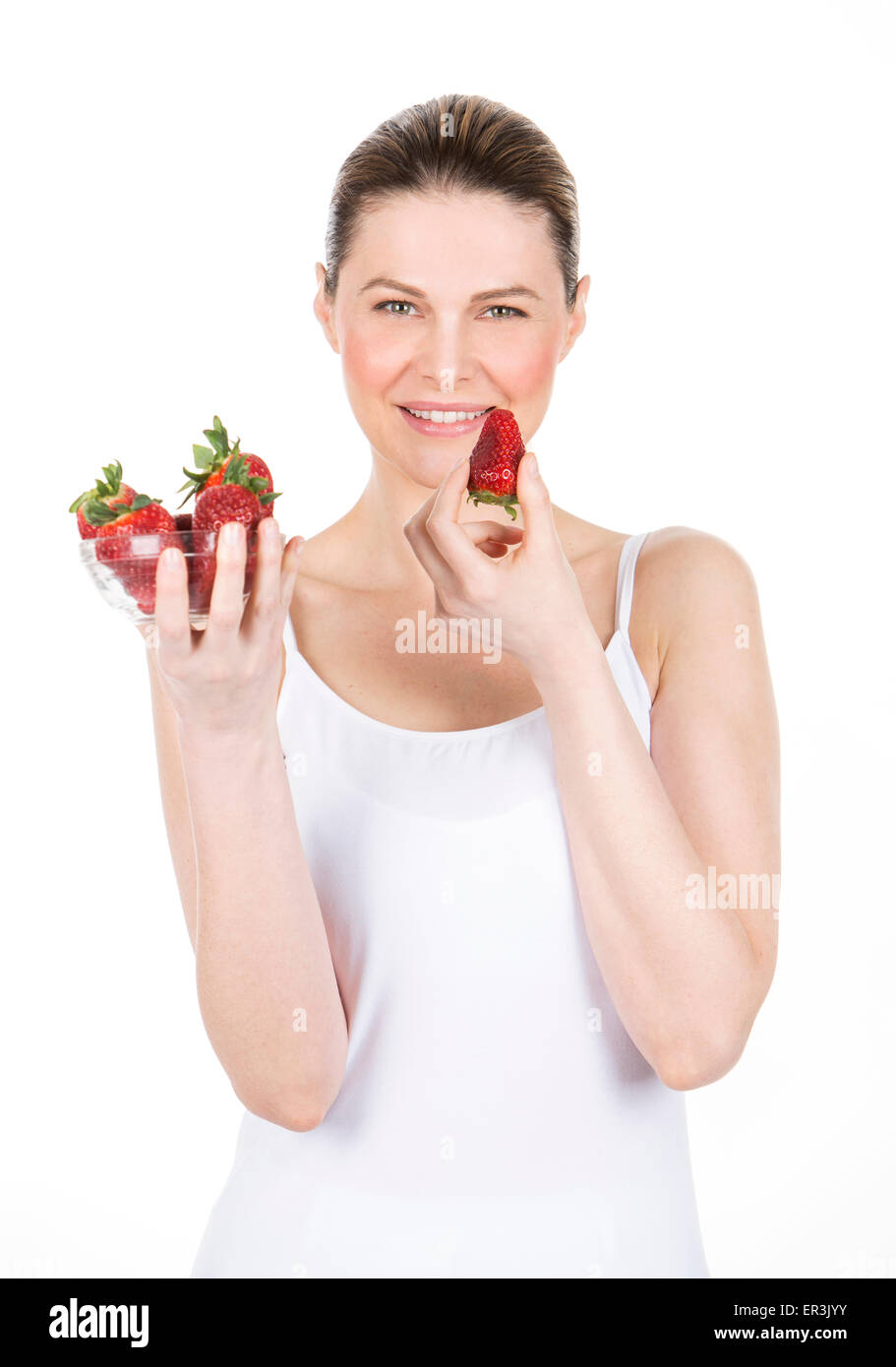 Frau mit weißem Kleid hält einige Erdbeeren Stockfoto