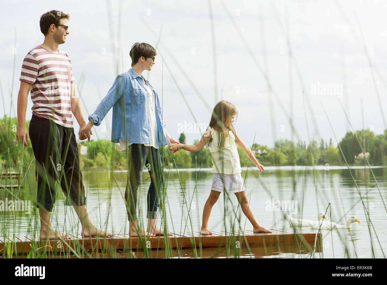 Familie Hand in Hand auf dock Stockfoto