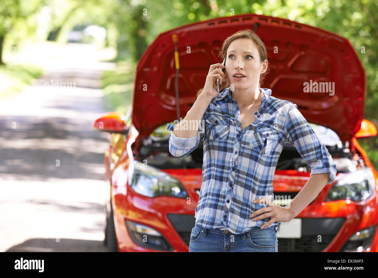 Weiblichen Autofahrer telefonieren für Hilfe nach Zusammenbruch Stockfoto