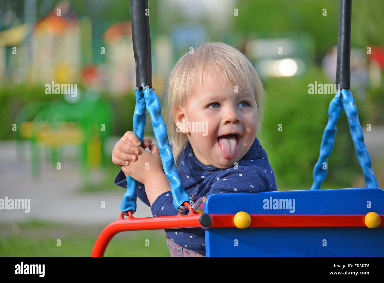 Entzückende kleine Mädchen, die Spaß auf einer Schaukel im freien Stockfoto
