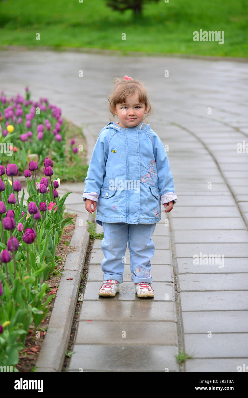 Kleines Mädchen in der Nähe die Beete mit einem Tulpen Stockfoto