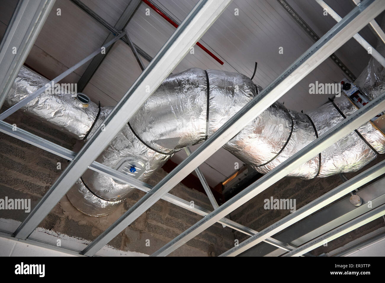 obenliegende Luftabsaugung Konditionierung Leitungsrohre in einem Industriegebäude im Bau im Vereinigten Königreich Stockfoto
