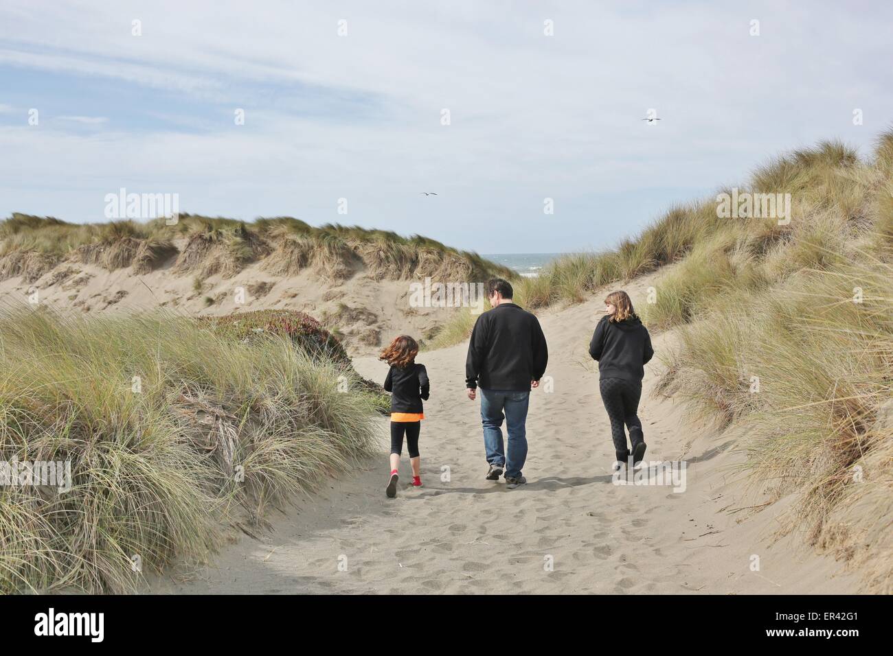 Eine junge Familie, Wandern in den Dünen in der Nähe eines Strandes. Stockfoto