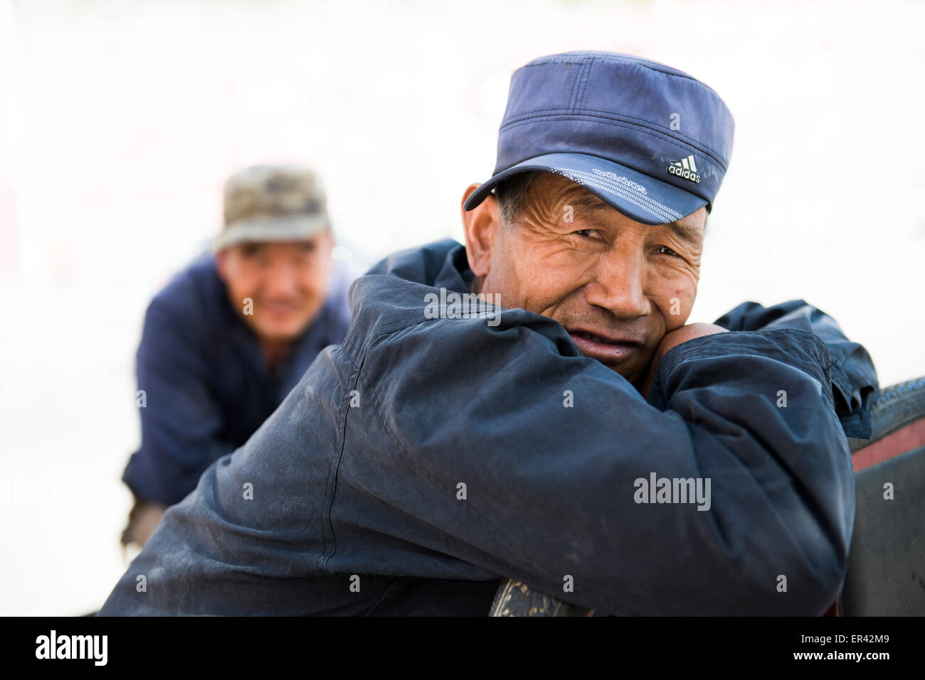 Ein chinesischer Mann trägt eine blaue Adidas Mütze Stockfotografie - Alamy