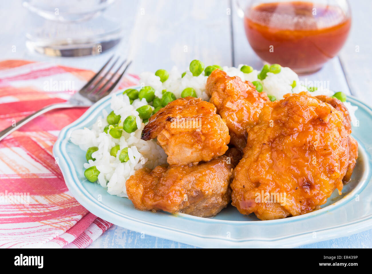 Hähnchenschenkel mariniert und gebacken in russischen Dressing-Sauce, serviert mit Reis und Erbsen Stockfoto