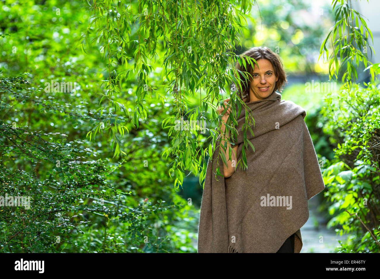 Charmante junge Frau im Park unter den grünen Bäumen. Stockfoto