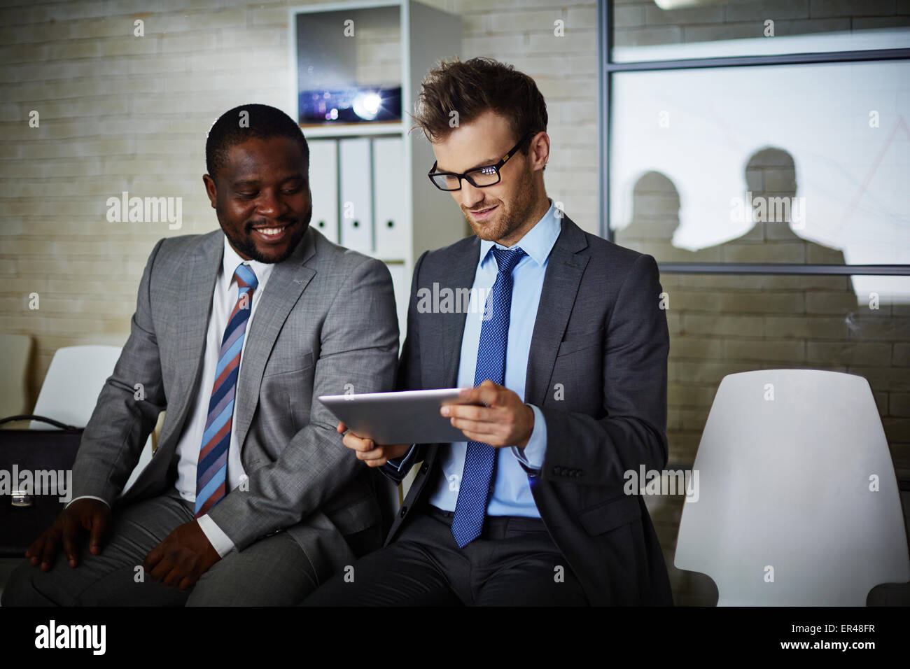 Zwei männliche Kollegen Blick durch Daten im Büro Stockfoto