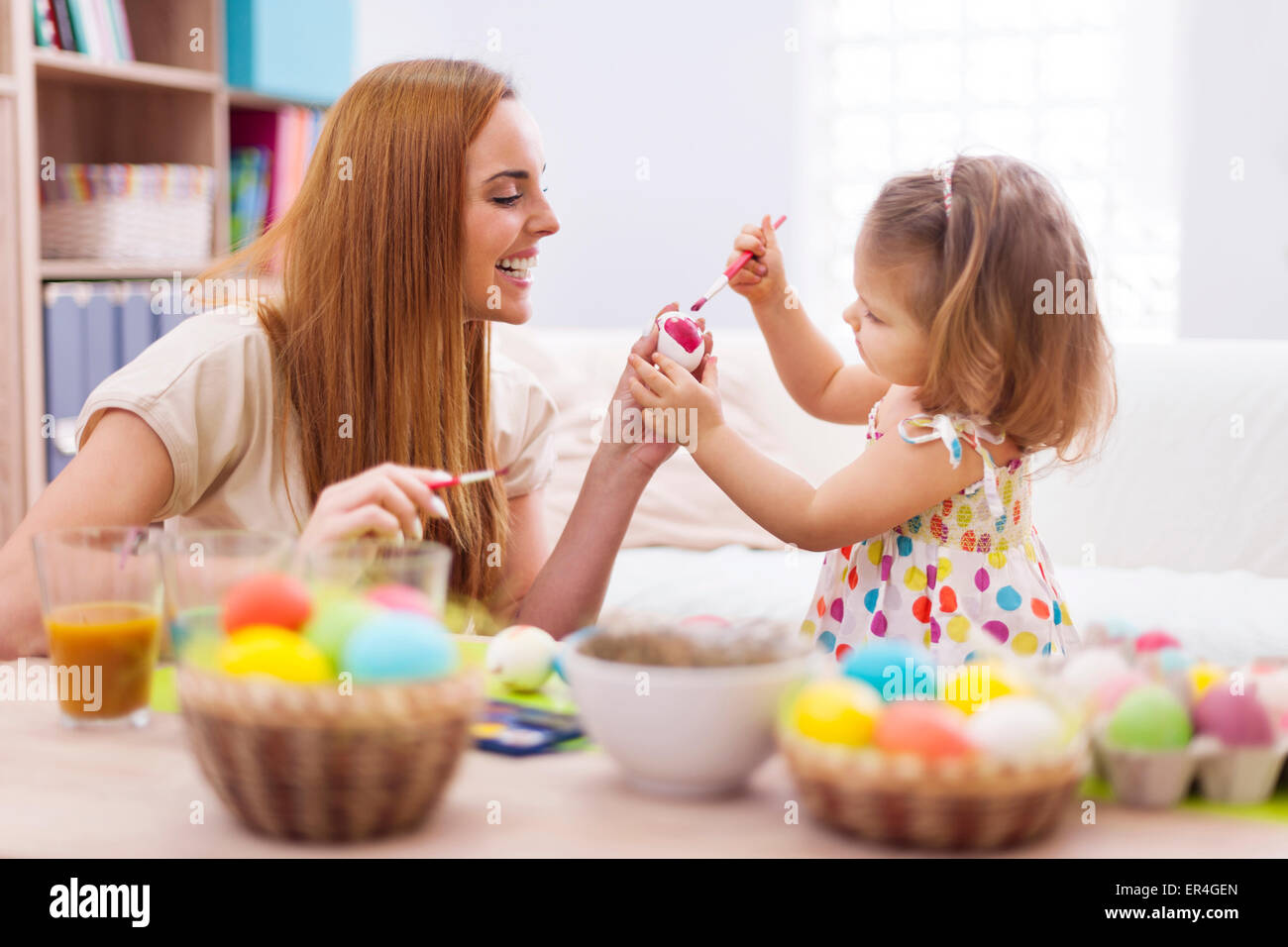 Glückliche Mutter helfen Baby auf Ostereier malen. Debica, Polen Stockfoto