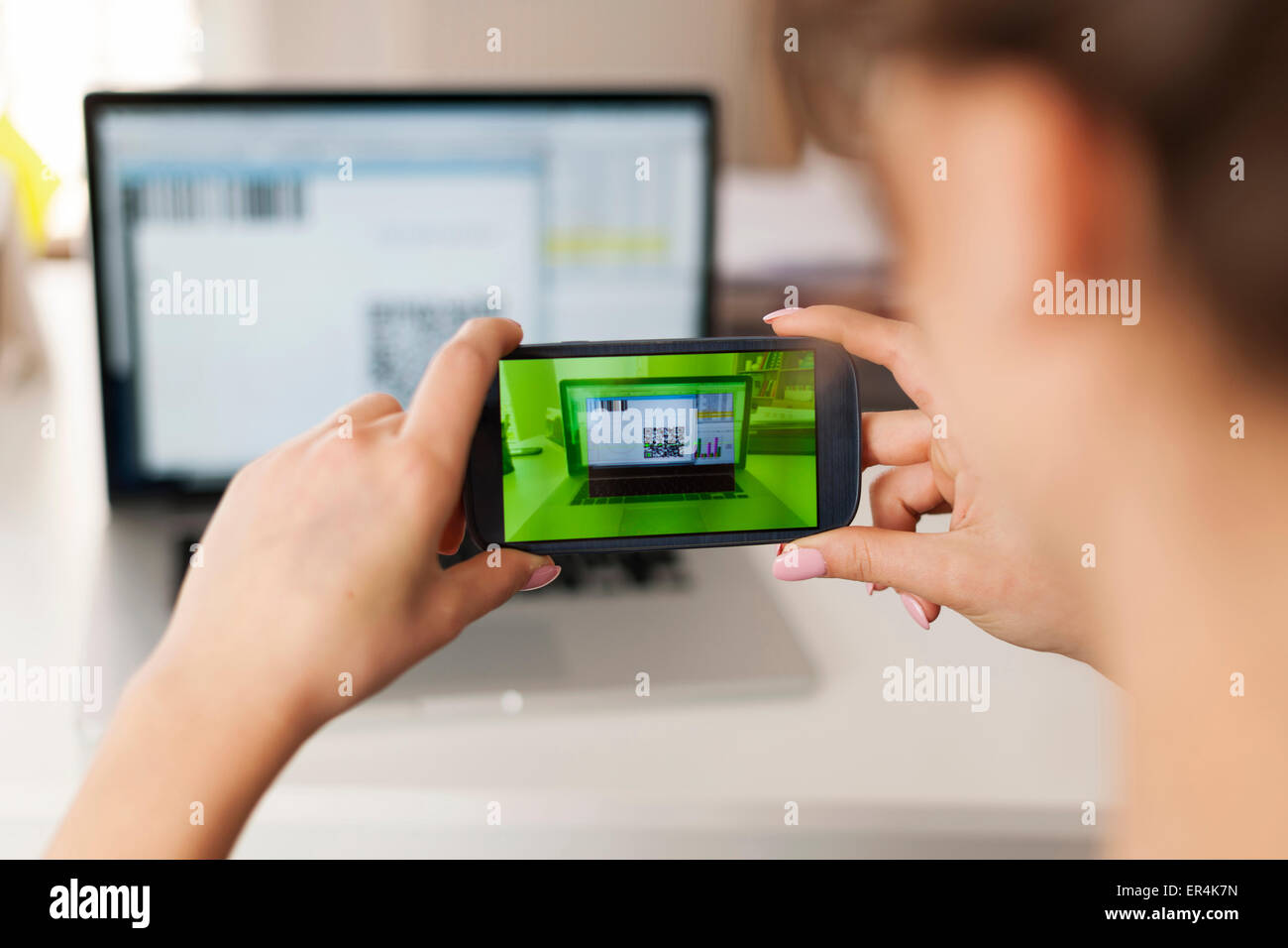 Frau qr-Code scannen, um Rechnungen zu bezahlen. Debica, Polen Stockfoto