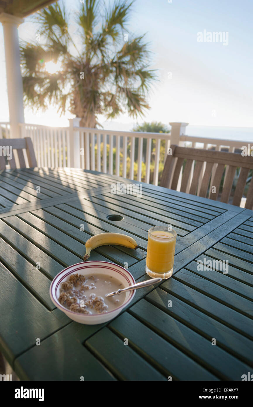 Frühstücks-Cerealien Terrasse Deck mit Sonnenschein & Palme Stockfoto