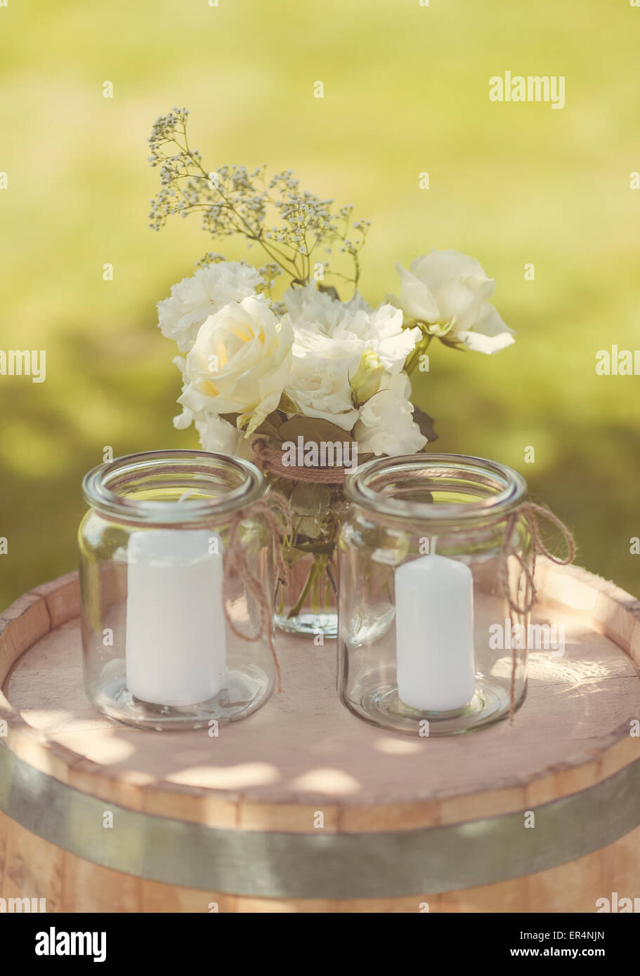 Kerzen und Blumen auf einem Fass Stockfoto