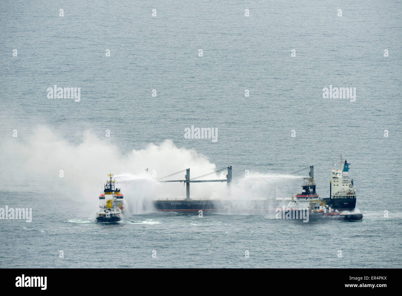 Cuxhaven, Deutschland. 26. Mai 2015. Der Notfall Meer Schlepper "Nordic" und das Mehrzweck-Schiff "Neuwerk" löschen das Feuer an Bord der brennenden Frachter "Purple Beach" in der Nordsee in der Nähe von deutschen Insel Helgoland, Deutschland, 27. Mai 2015. Die Besatzung des Frachters Marshall Inseln registriert hatte bemerkt, Rauch in der Ladung hält am 25 Mai abends, ein Sprecher für das Havariekommando in Cuxhaven, Deutschland, am 26. Mai 2015 angegeben. Bildnachweis: Dpa picture Alliance/Alamy Live News Stockfoto