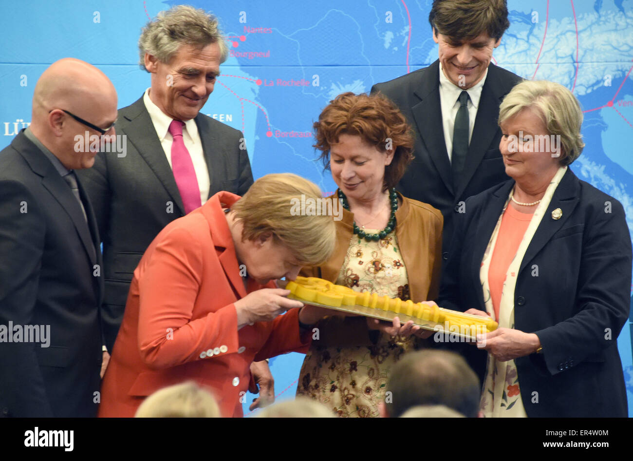 Bundeskanzlerin Angela Merkel (L, CDU) riecht an einen symbolischen Schlüssel aus Marzipan während der Eröffnung des Europäischen Hansemuseum Lübeck, 27. Mai 2015. Schleswig-Holsteins Ministerpräsident Torsten Albig (SPD, L-R), Lübeckers Bürgermeister Bernd Saxe (SPD), Direktor des Hansemuseum Lisa Kosok, Architekten Andreas Heller und Vorsitzende der Possehl-Stiftung Renate Menken Stand neben ihr. Das Museum wurde nach einer dreijährigen langen Bauphase eröffnet und zeigt die Entwicklung der Hanse von seinen Anfängen im 12. Jahrhundert zu einer wirtschaftlichen und politischen Macht, die beherrscht die lo Stockfoto