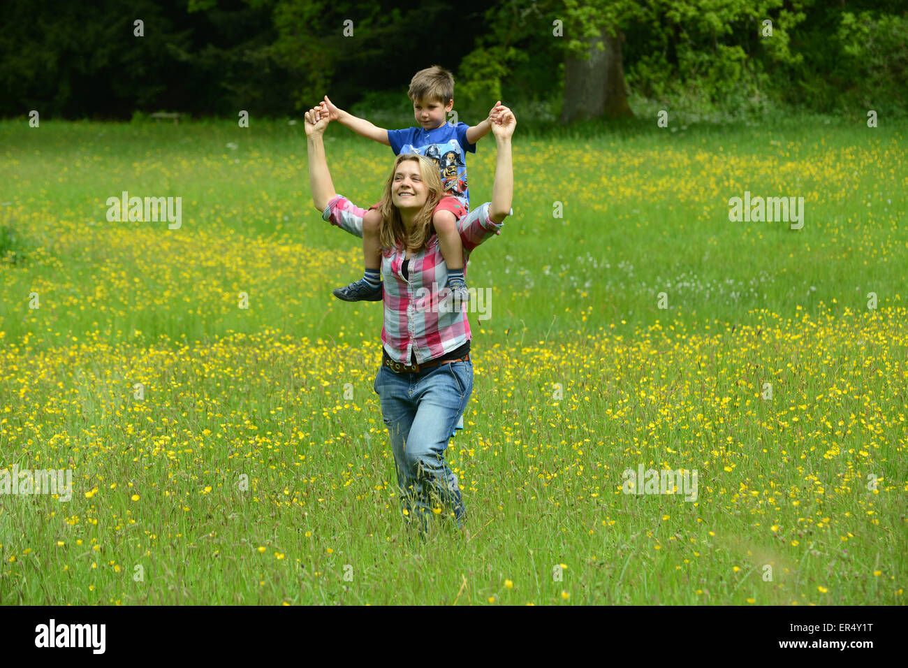 Frau Mutter und Kind zu Fuß durch Butterblume Wiese im Frühjahr Uk Stockfoto
