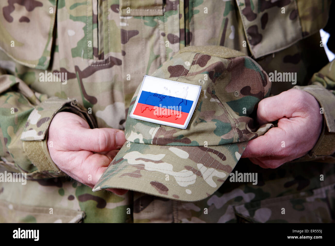 Mann in Kampfuniform hält russische Armee Camouflage Mütze Stockfoto