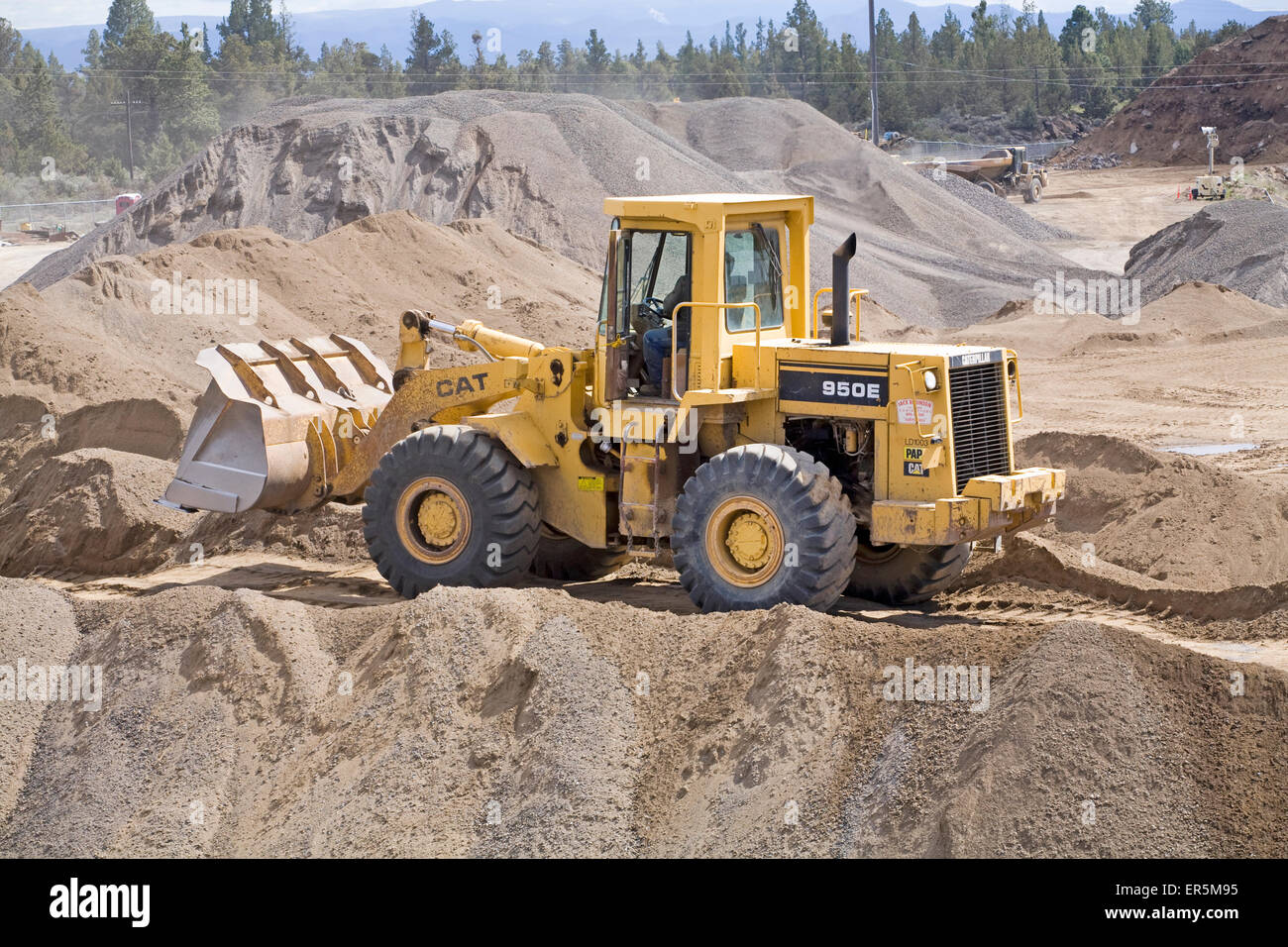 Ein Bagger Raupe 'Katze' 950E Pflüge in einen Haufen von Schmutz auf einer Baustelle in Zentral-oregon Stockfoto