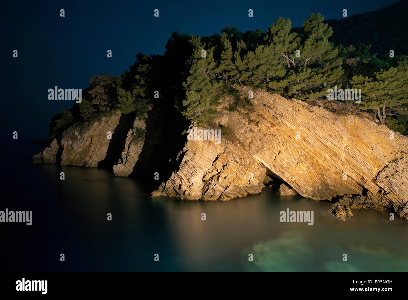 Nachtbeleuchtung Felsen entlang der Küste in Petrovac in der Nähe von Budva, Adriaküste, Montenegro, Western Balkan, Europa Stockfoto