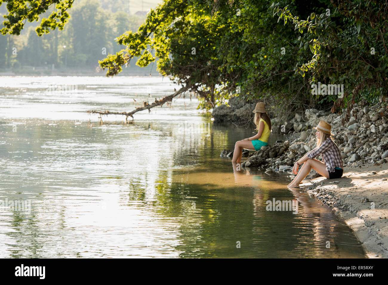 Zwei junge Frauen sitzen am Rhein, Rheinfelden, Baden-Württemberg, Deutschland Stockfoto
