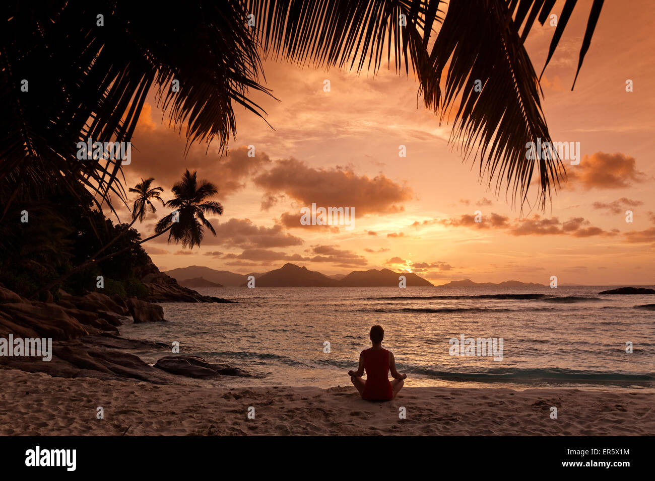 Yoga bei Sonnenuntergang am Anse Severe beach, Palmen, La Digue, Seychellen, Indischer Ozean Stockfoto
