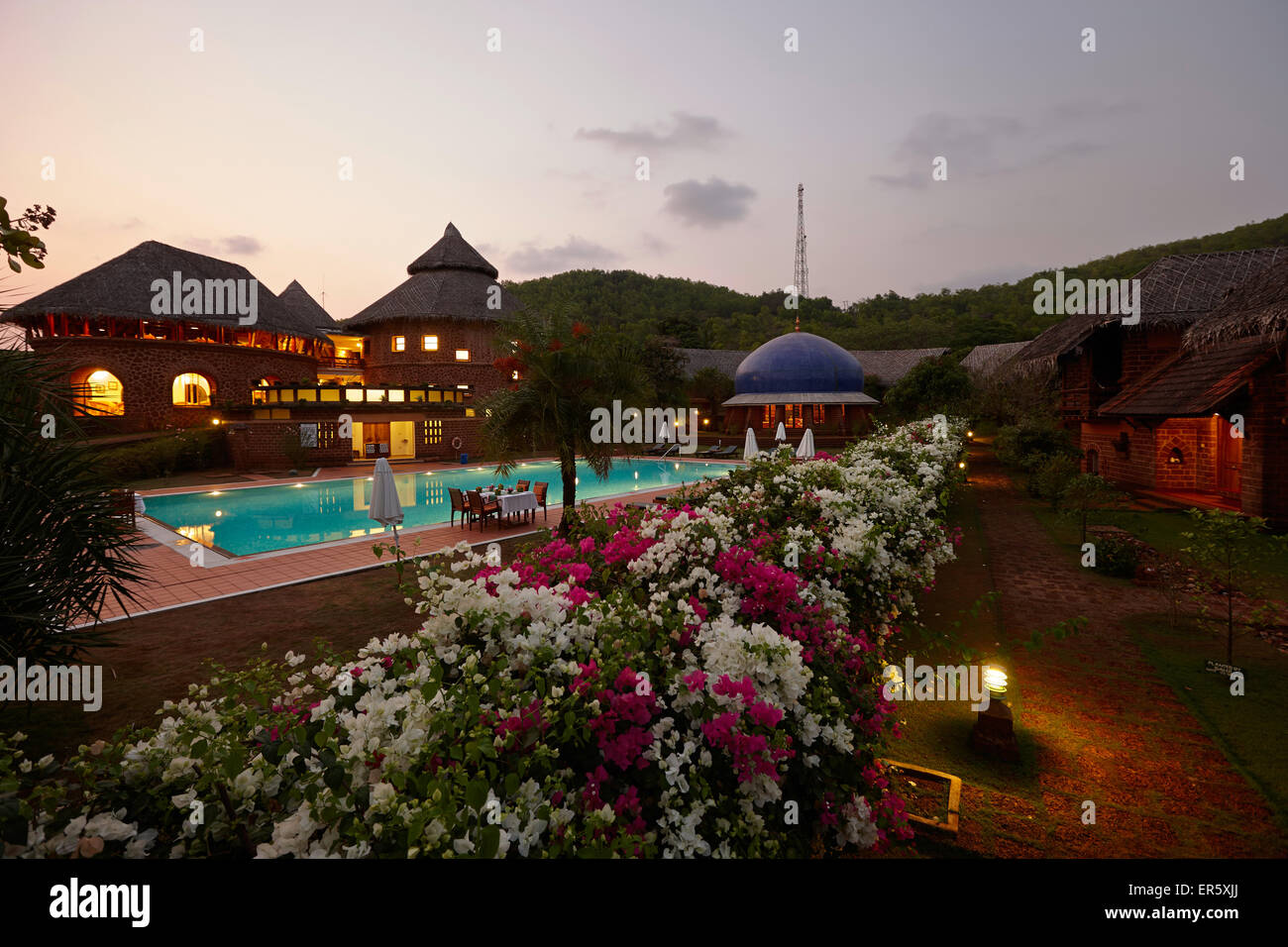 Pool, Restaurant und Bungalows des Hotels am Abend Gokarna, Karnataka, Indien Stockfoto