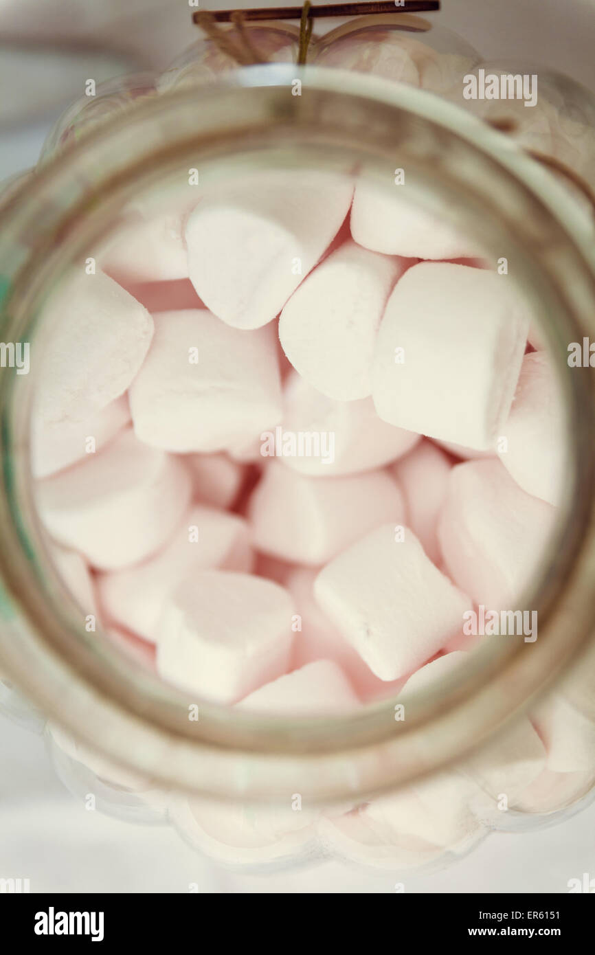 Blickte auf ein Glas voller rosa Marshmallow Süßigkeiten.  Das Bild wurde mit einem Retro-Filmsimulation behandelt. Stockfoto