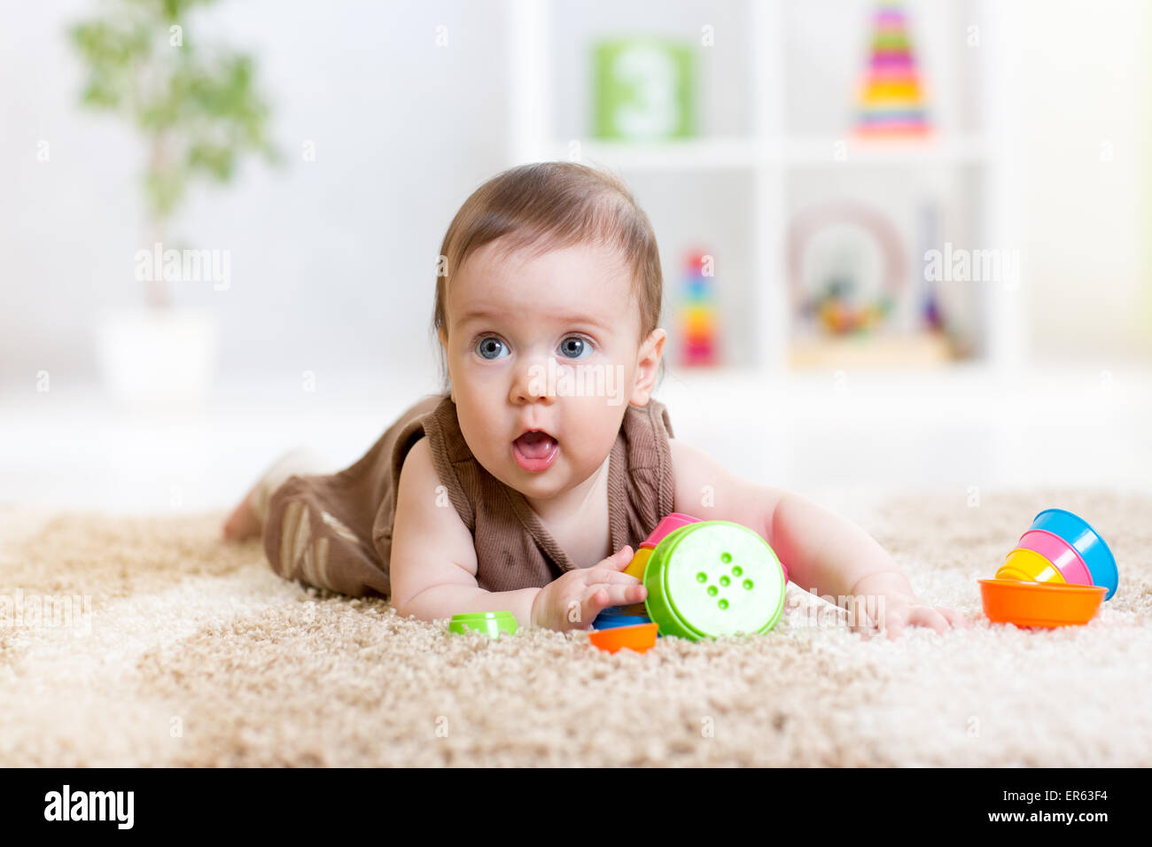 Babymädchen spielen mit Spielzeug drinnen zu Hause Stockfoto