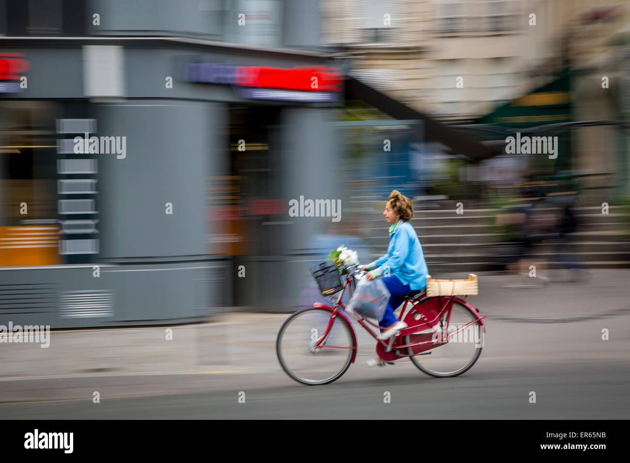Schwenken der Ansicht von Frau Reiten Fahrrad in Les Marais, Paris, Frankreich Stockfoto