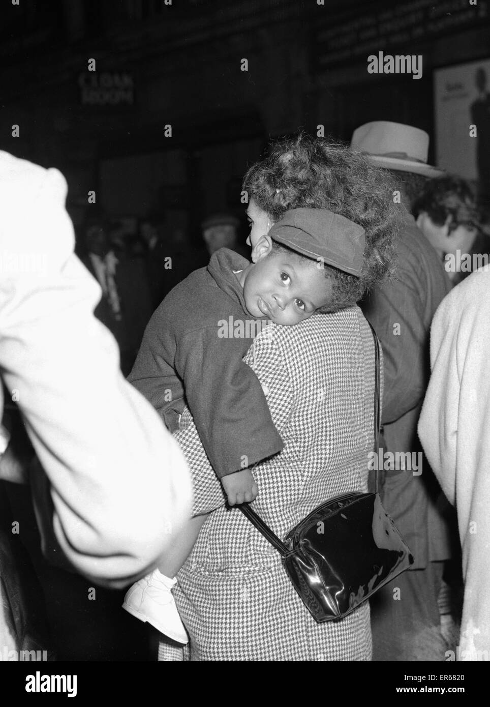 Ein müde kleine Reisender bekommt eine helfende Hand von seiner Mutter. Wie sie an der Paddington Station nahe dem Ende ihrer Reise aus Jamaika, um ein neues Leben beginnen im Vereinigten Königreich ankommen. 1. Mai 1955 Stockfoto
