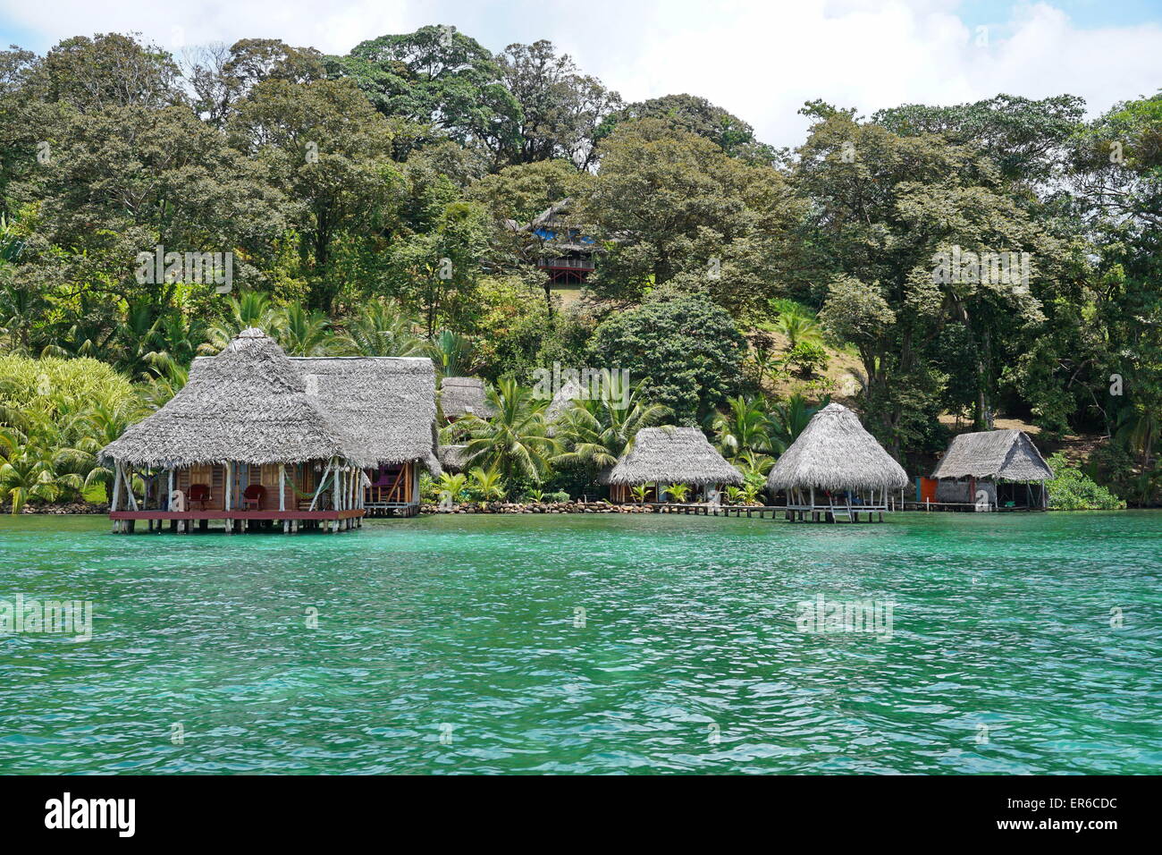 Waterfront Ecolodge mit strohgedeckten Hütte Overwater und üppiger tropischer Vegetation auf dem Land, Karibikseite von Panama, Central Stockfoto