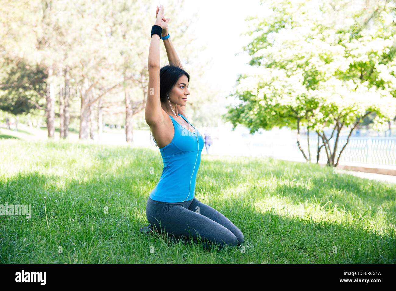 Schöne Frau, die Yoga-Übungen auf dem grünen Rasen im park Stockfoto