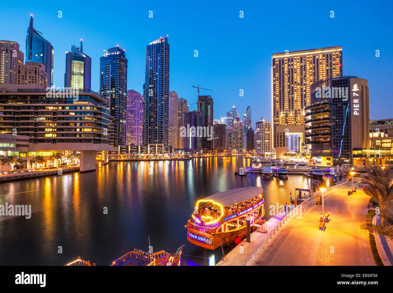 Skyline von Dubai Marina und touristische Boote bei Nacht Dubai Stadt Vereinigte Arabische Emirate VAE Naher Osten Stockfoto