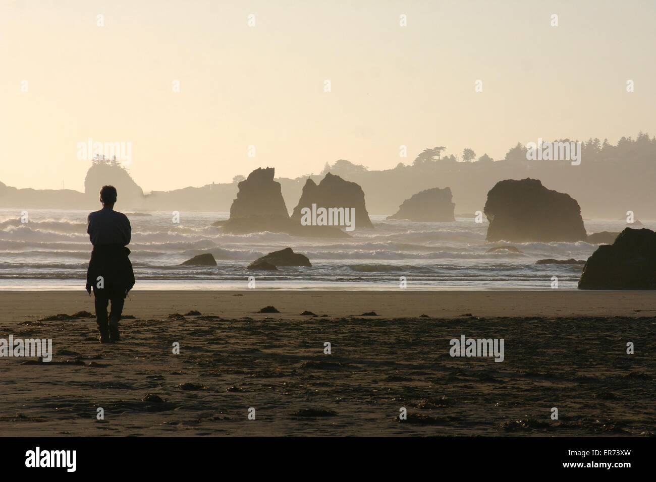 Menschen beobachten den Sonnenuntergang über Meer-Stacks am Strand von Trinidad Bay in California Coastal National Monument in Kalifornien. Das Denkmal besteht aus mehr als 20.000 Inselchen, Felsen, Riffe ausgesetzt und Zinnen erstreckt sich die Länge des Staates zwischen Mexiko und Oregon. Stockfoto