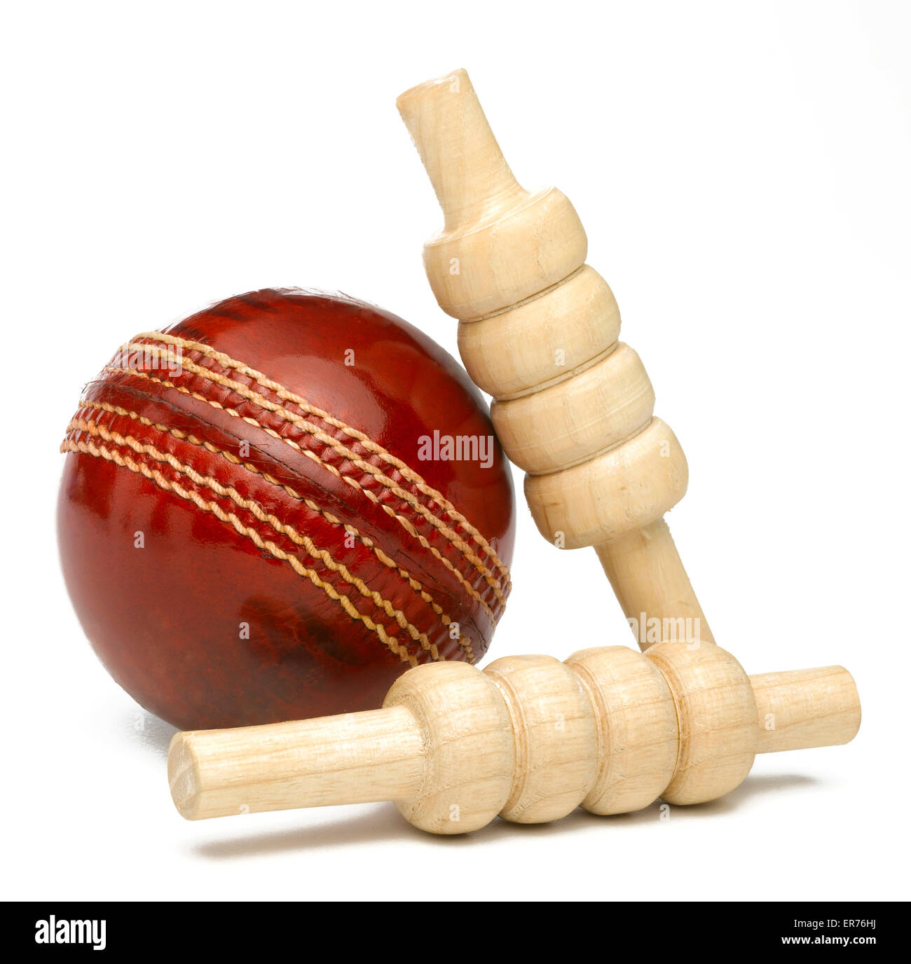 Cricketball und Kautionen isoliert auf weiss Stockfoto