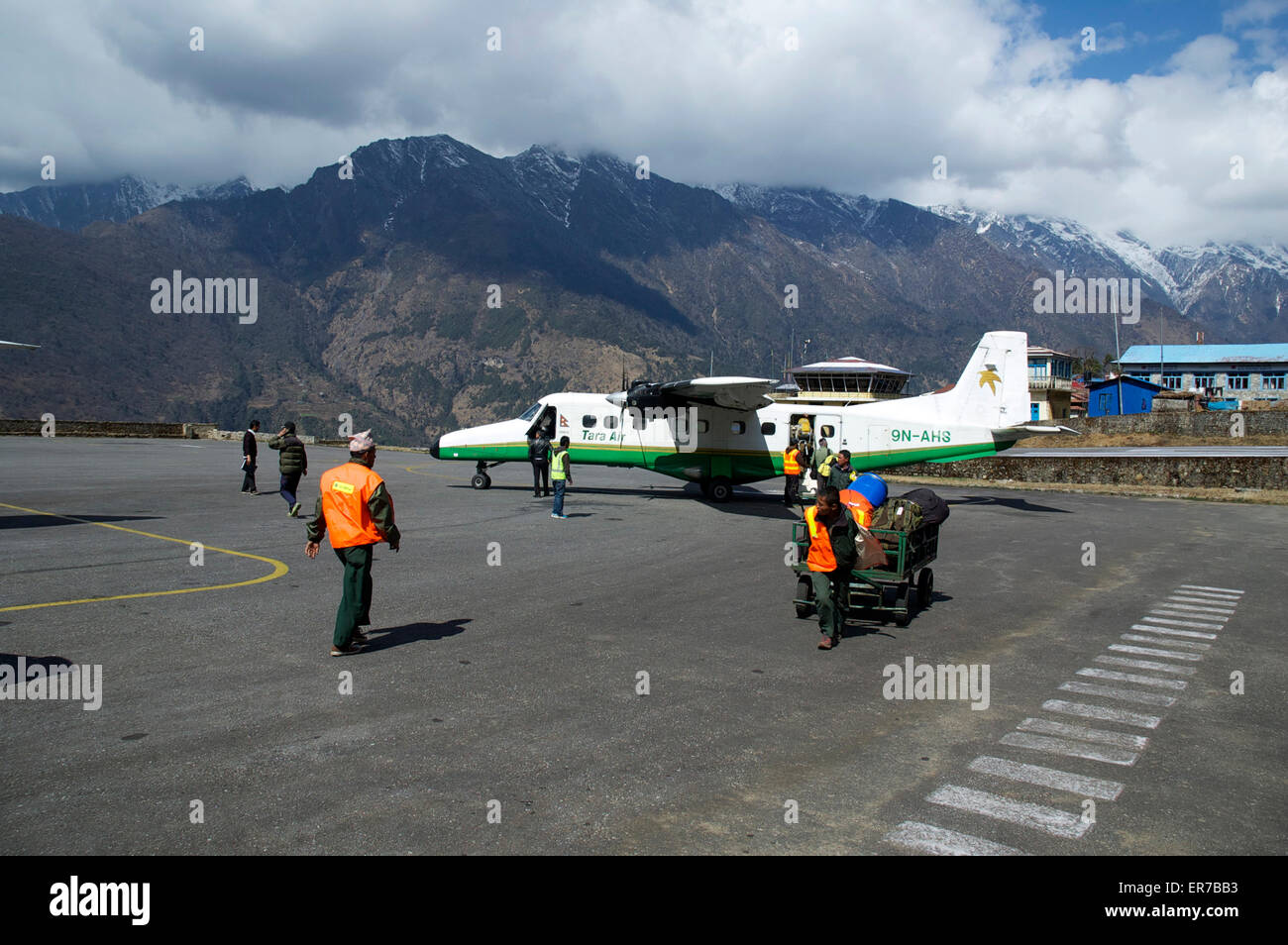 Bodenpersonal entladen Gepäck von einer Tara Air Dornier 228 in Lukla Airport, Nepal. Stockfoto