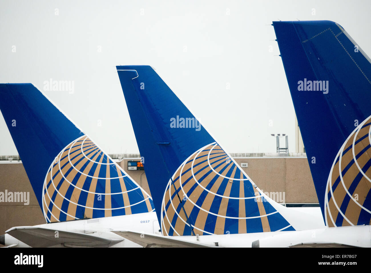 Eine Reihe von drei Schwänzen von United Airlines Flugzeuge aufgereiht am Gate am Flughafen. Jede Rute hat das neue United-Logo nach der Fusion mit Continental Airlines. Stockfoto