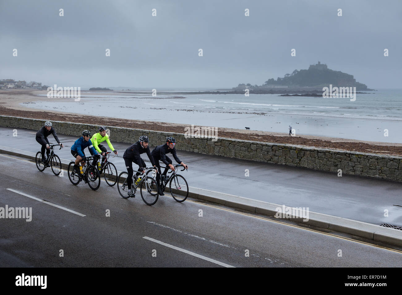 Radfahrer fahren vorbei an St Micheal Mount in Cornwall Stockfoto