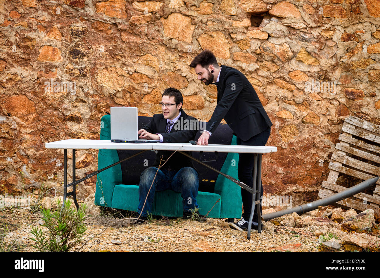 Zwei Jungs um einen Schreibtisch in einem Grunge-Büro, ein Konkurs-Konzept Stockfoto