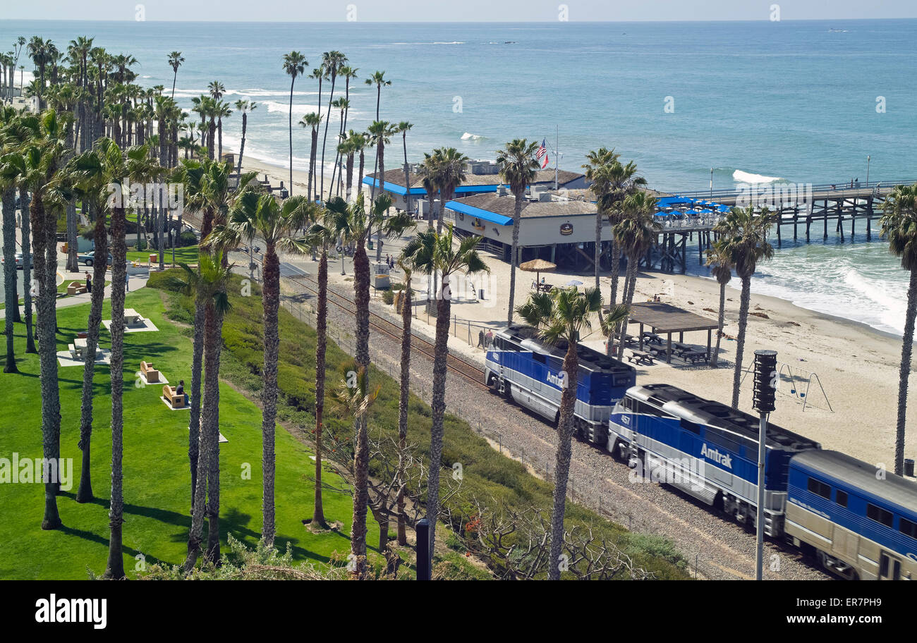 Passagiere auf einen Amtrak-Zug genießen Sie einen herrlichen Blick auf den Pazifischen Ozean, wie sie vorbei an der San Clemente Pier in Kalifornien, USA Geschwindigkeit Stockfoto
