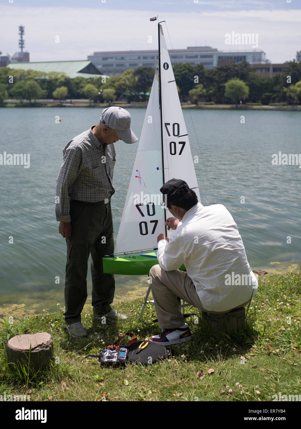 Japanische Rentner entspannend mit einem Modell Boot am Ohori Koen (Park) Stadt Fukuoka, Kyushu, Japan Stockfoto