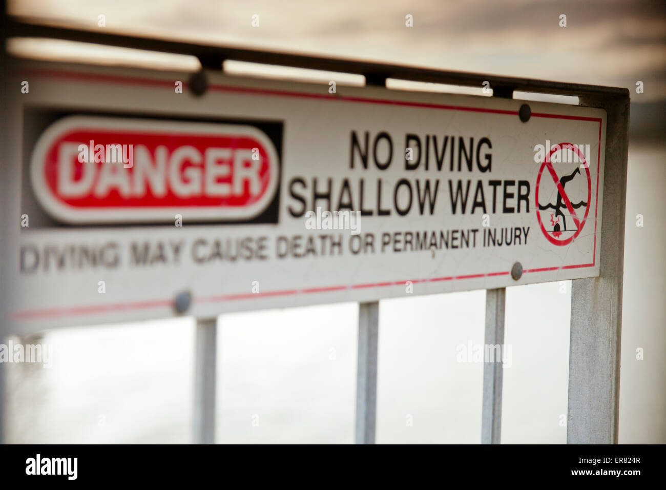 Ein Schild warnt Benutzer nicht, ins seichte Wasser zu tauchen. Stockfoto