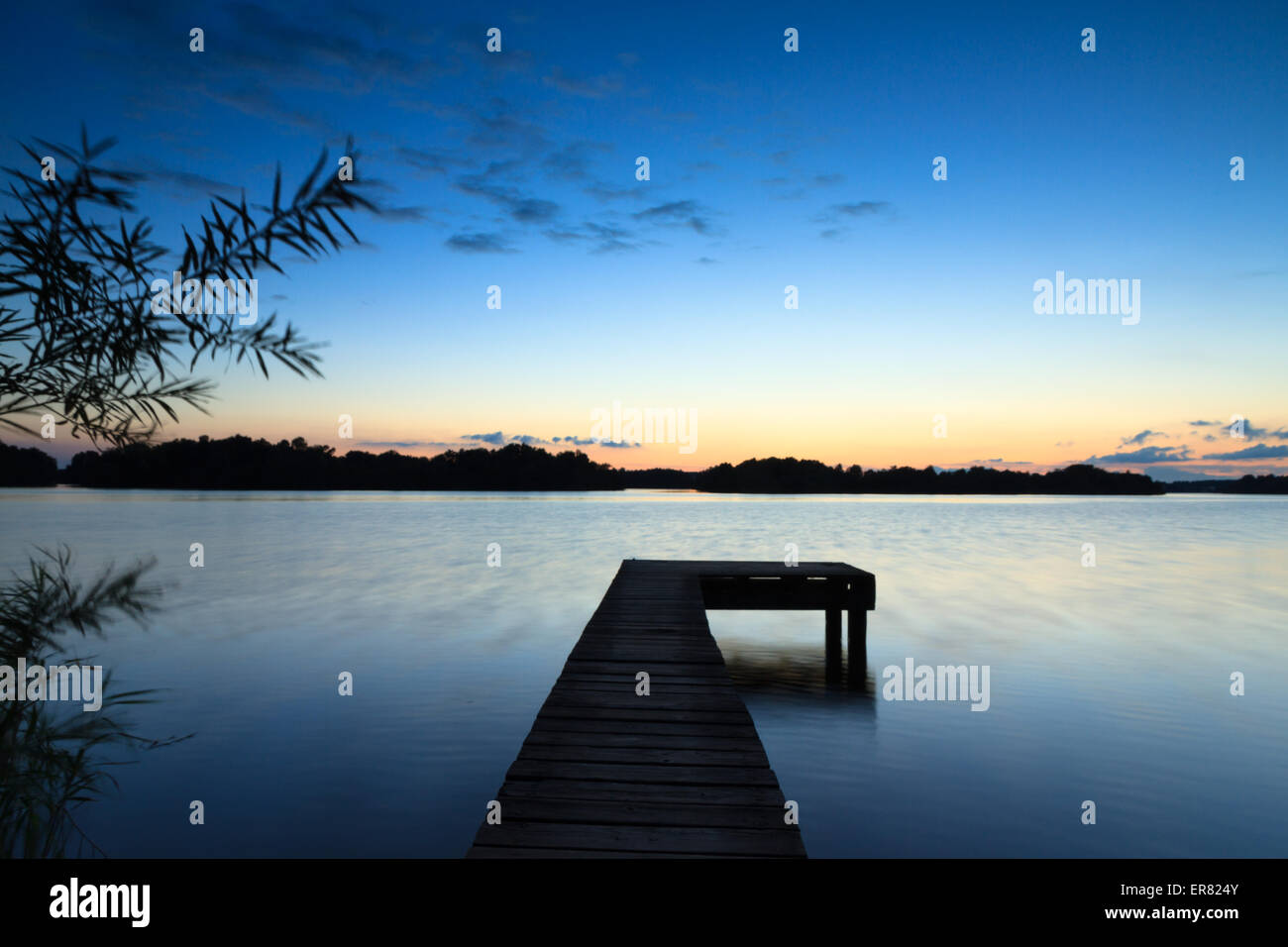 Kleiner Steg an einem See in der Abenddämmerung. Stockfoto