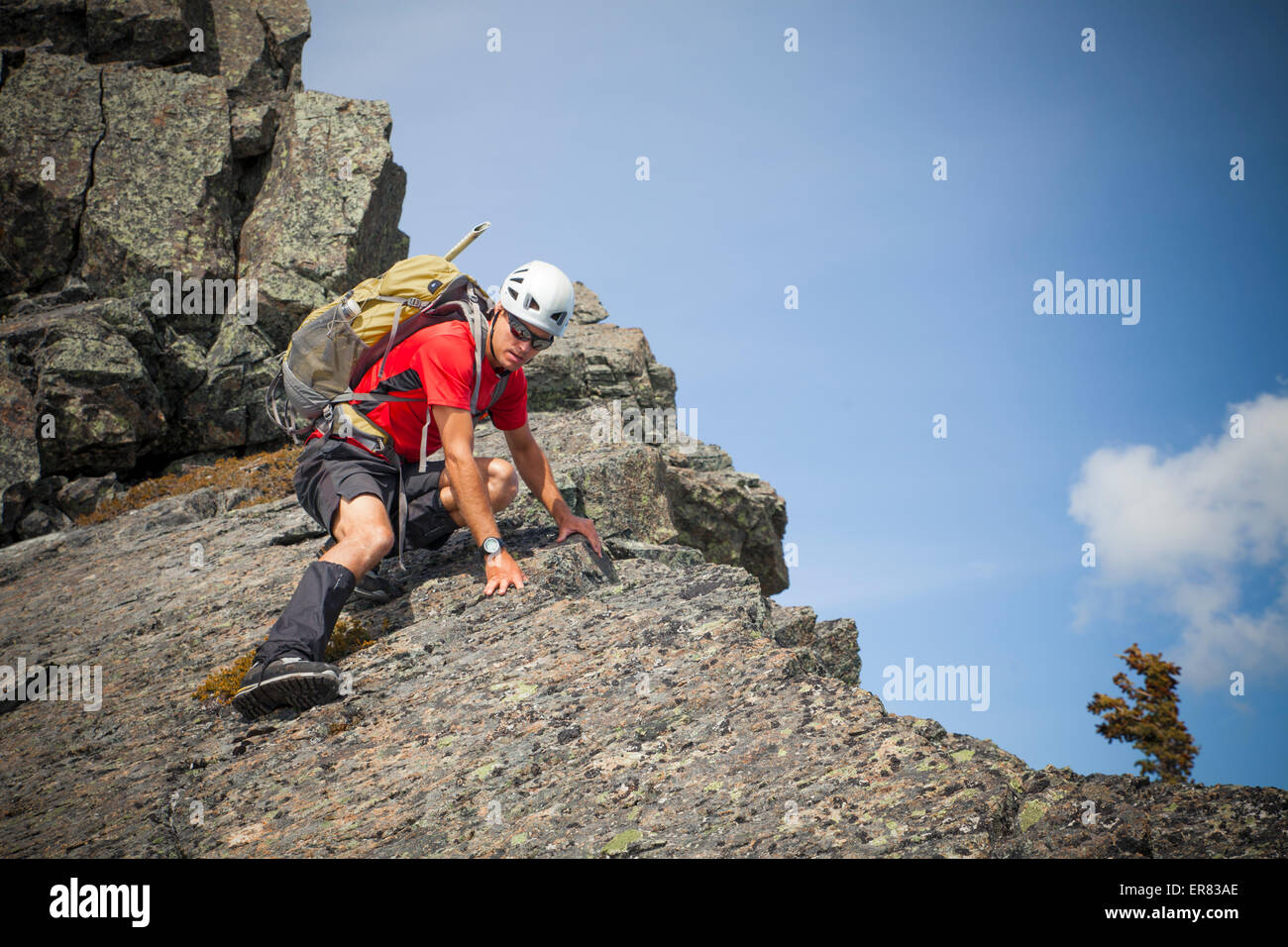 Ein Bergsteiger vorsichtig nach unten klettert einen felsigen Gipfel in Britisch-Kolumbien Stockfoto
