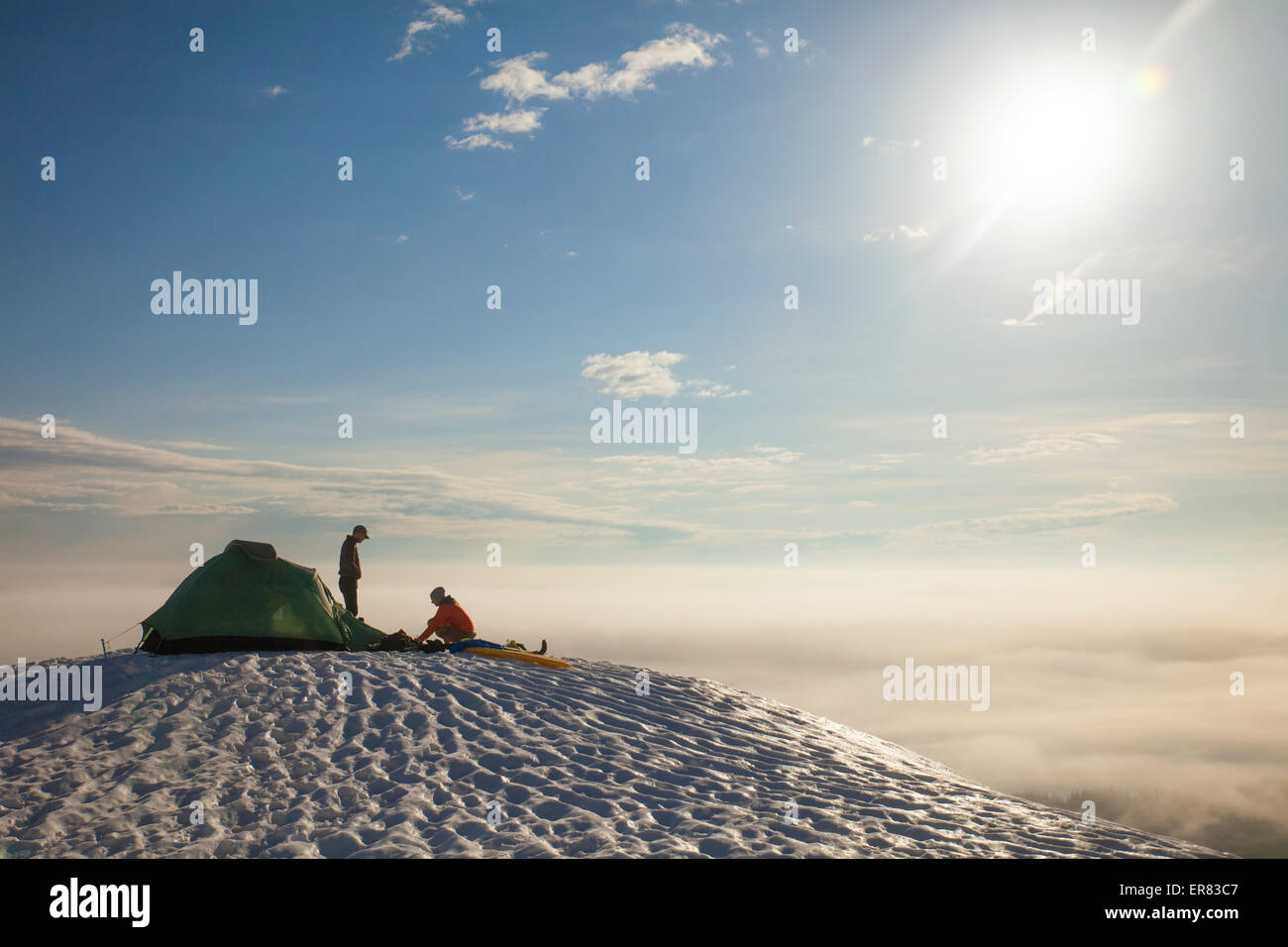 Zwei Kletterer sortieren ihre Ausrüstung neben ihrem Zelt beim camping. Stockfoto