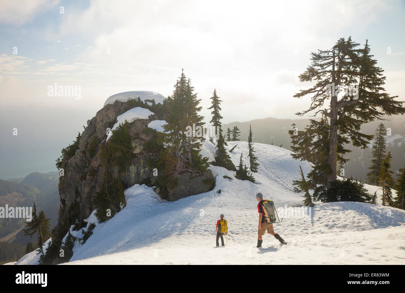 Zwei Bergsteiger steigen ein Schneefeld nach einem Ausflug in die Berge. Stockfoto