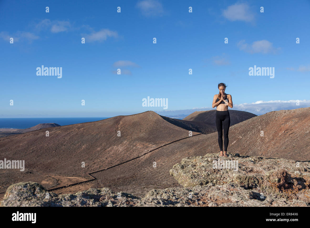 Mädchen beim Yoga auf dem Gipfel eines Vulkans in Fuerteventura, Kanarische Inseln Stockfoto