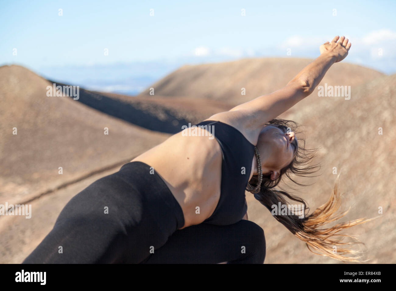 Mädchen beim Yoga auf dem Gipfel eines Vulkans in Fuerteventura, Kanarische Inseln Stockfoto