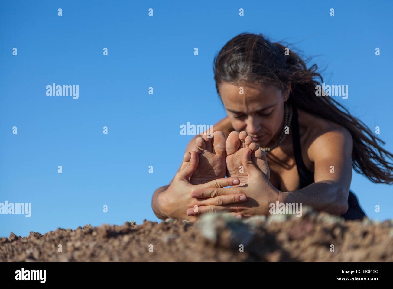 Mädchen beim Yoga auf dem Gipfel eines Vulkans in Fuerteventura, Kanarische Inseln Stockfoto