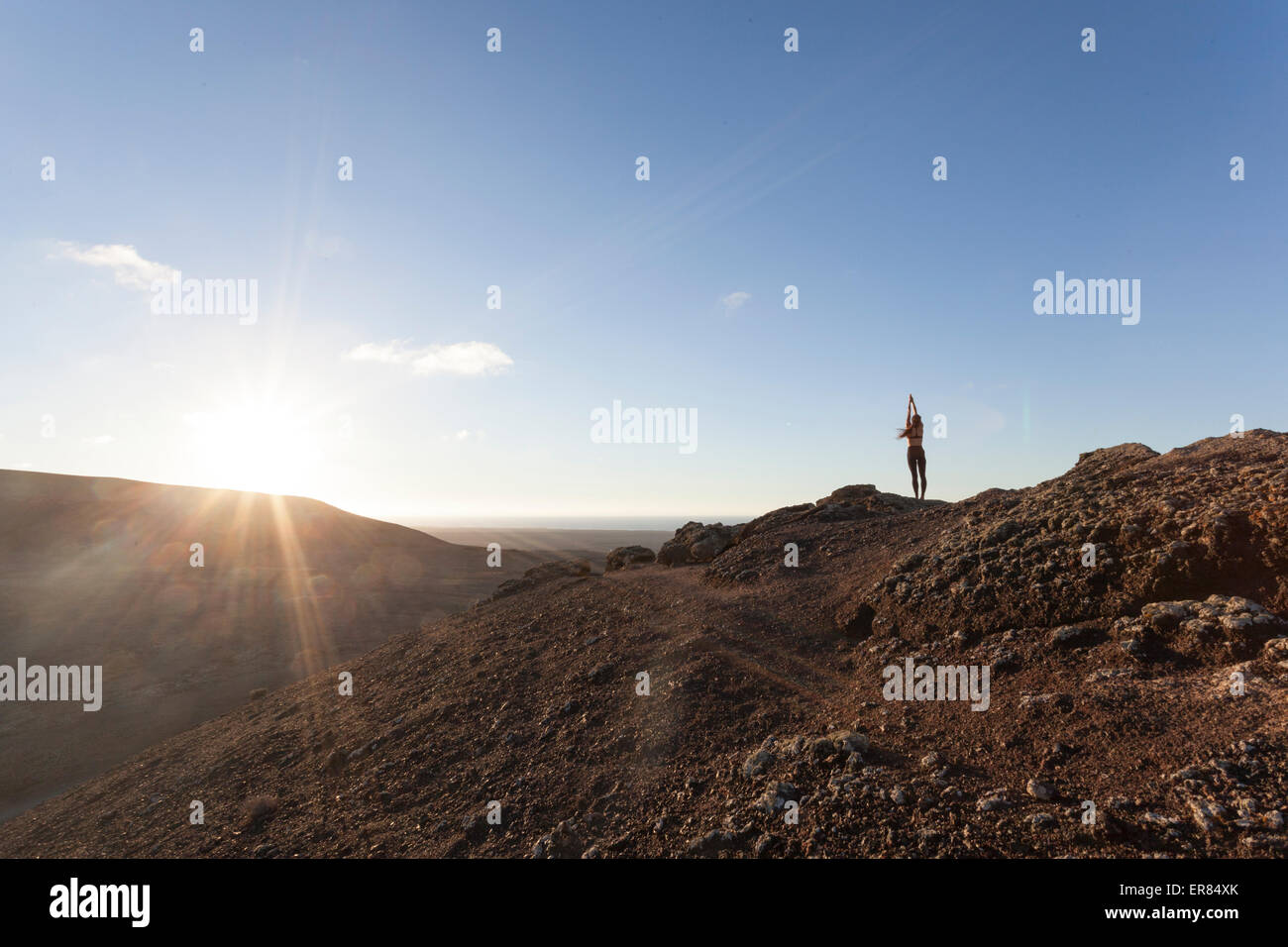 Mädchen beim Yoga auf dem Gipfel eines Vulkans in Fuerteventura, Kanarische Inseln Stockfoto
