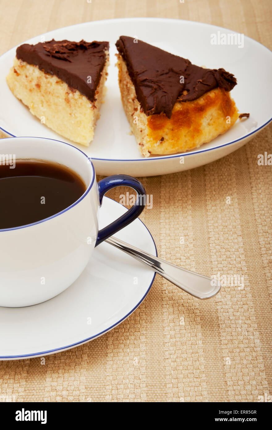 Nahaufnahme einer Tasse schwarzen Kaffees und Scheiben Stück Kuchen Stockfoto